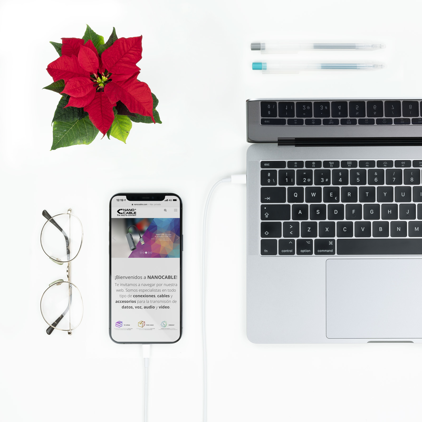Una configuración de escritorio con un iPad, un portátil, un teléfono, accesorios y una planta.