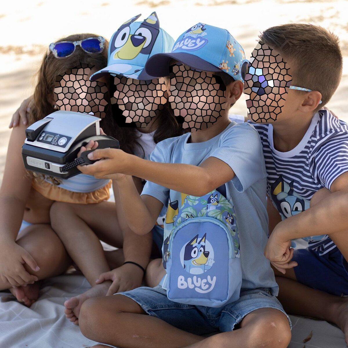 Cuatro niños en la playa. Uno sostiene una cámara. Llevan sombreros de Bluey y llevan una bolsa de Bluey.
