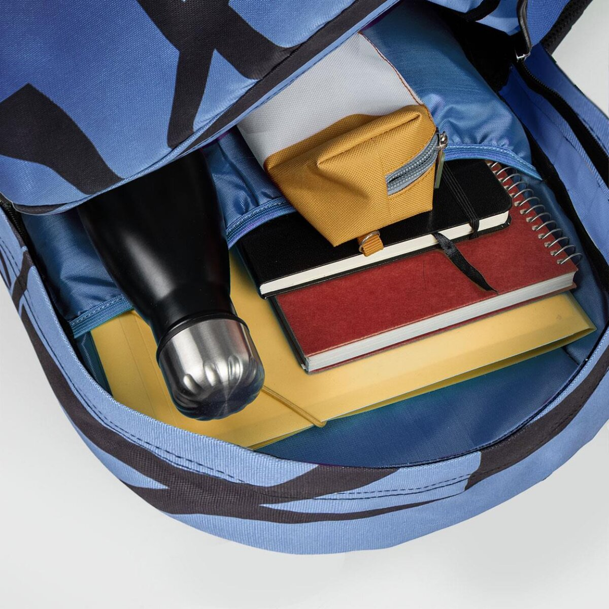 Mochila azul con detalles negros, abierta. Dentro: botella, cuadernos, estuche y carpetas.