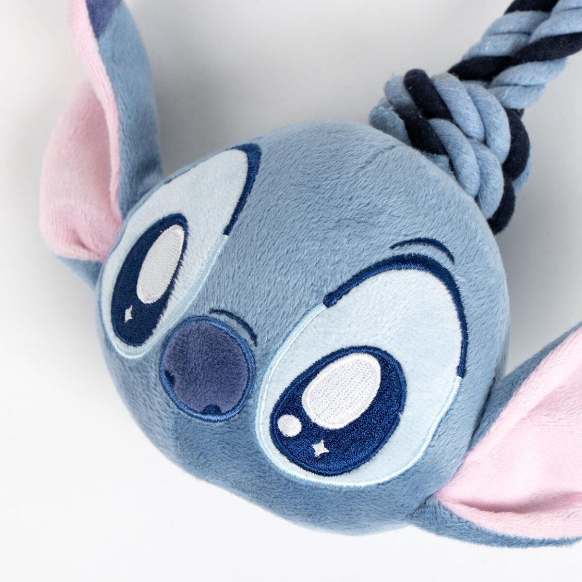 Ein blaues Stitch-Plüschtier mit einem geknoteten Seil. Weißer Hintergrund.