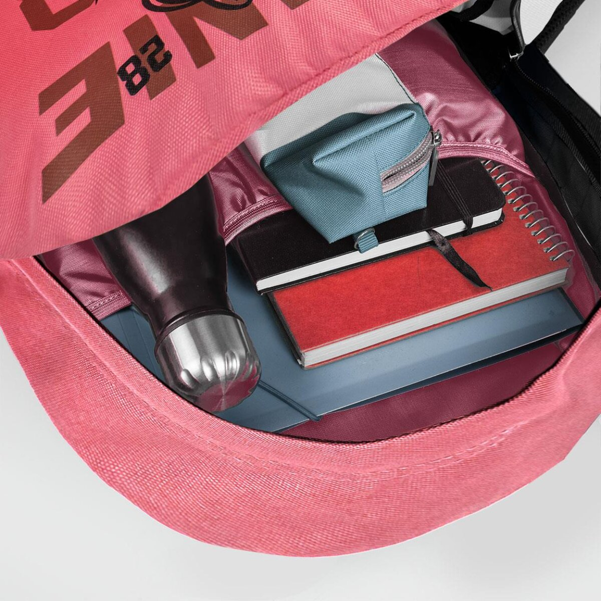 Offenes Rucksackinnere mit rotem Notizbuch, Wasserflasche und Federmäppchen.