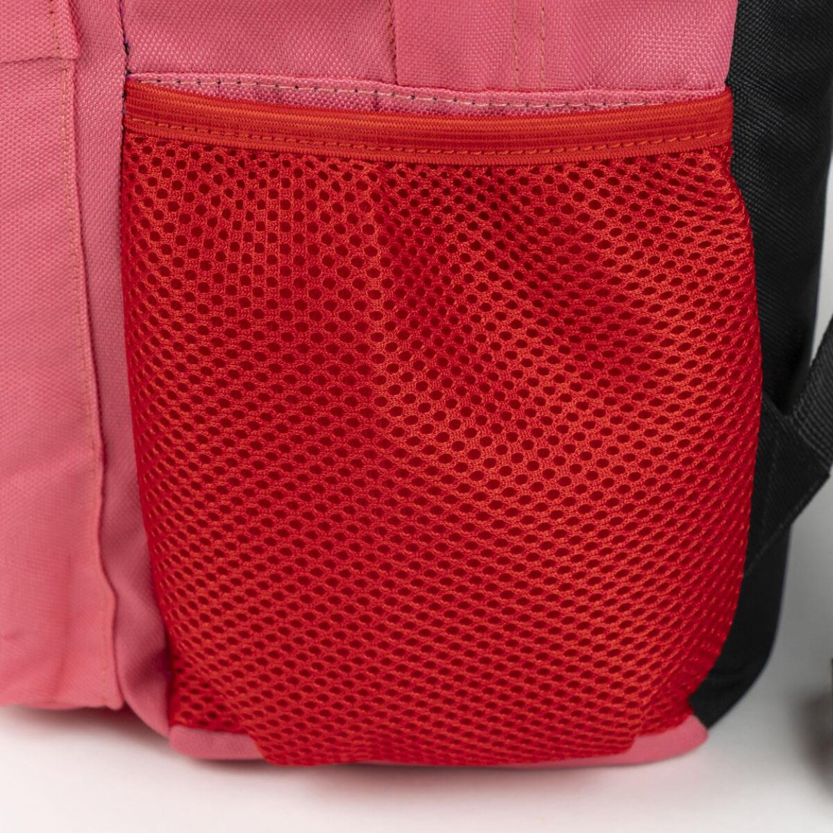 Nahaufnahme einer rosa und roten Netztasche auf einem Rucksack. Die Tasche befindet sich an der Seite.