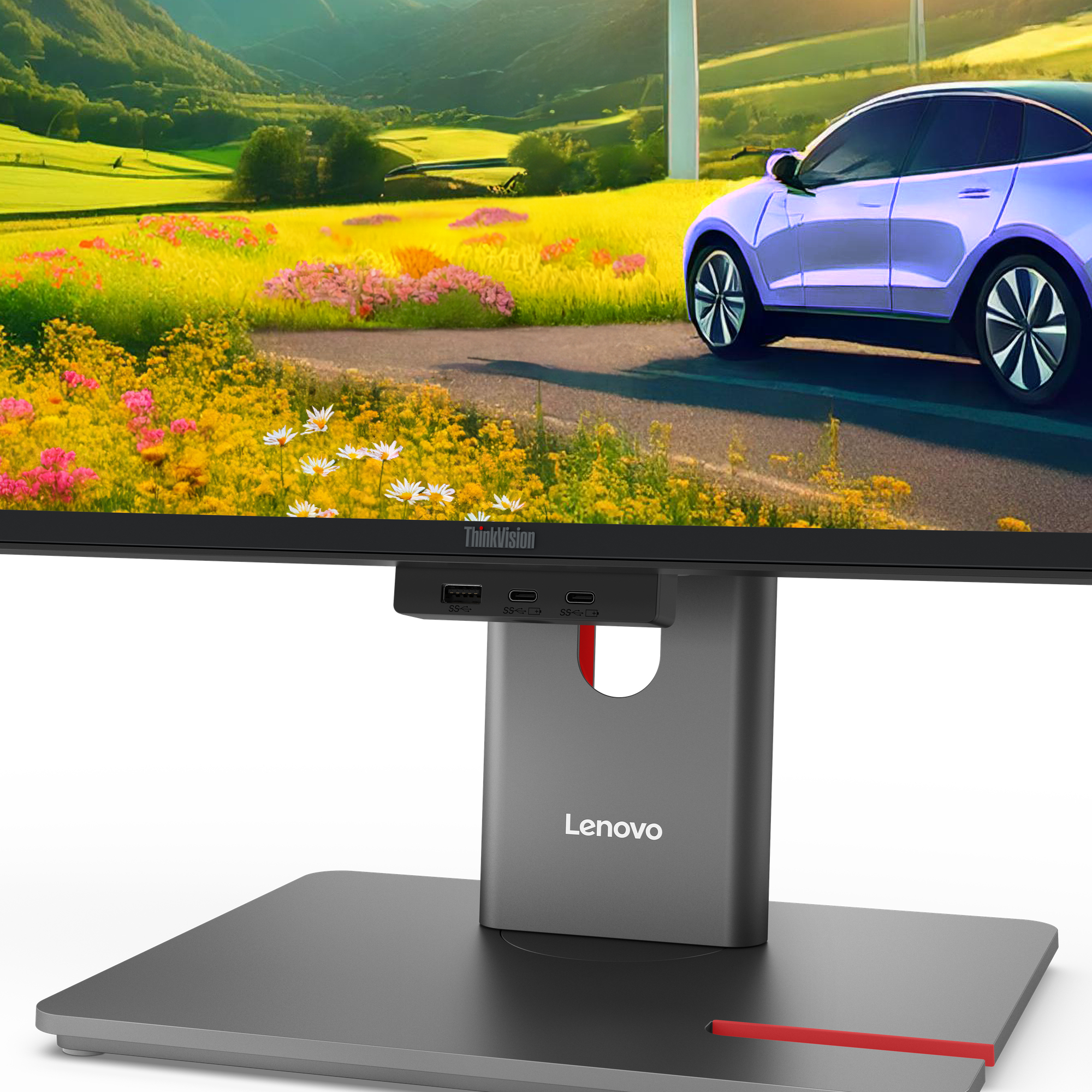 Zbliżenie monitora wyświetlającego krajobraz z niebieskim samochodem i turbinami wiatrowymi, prezentującego markę Lenovo.