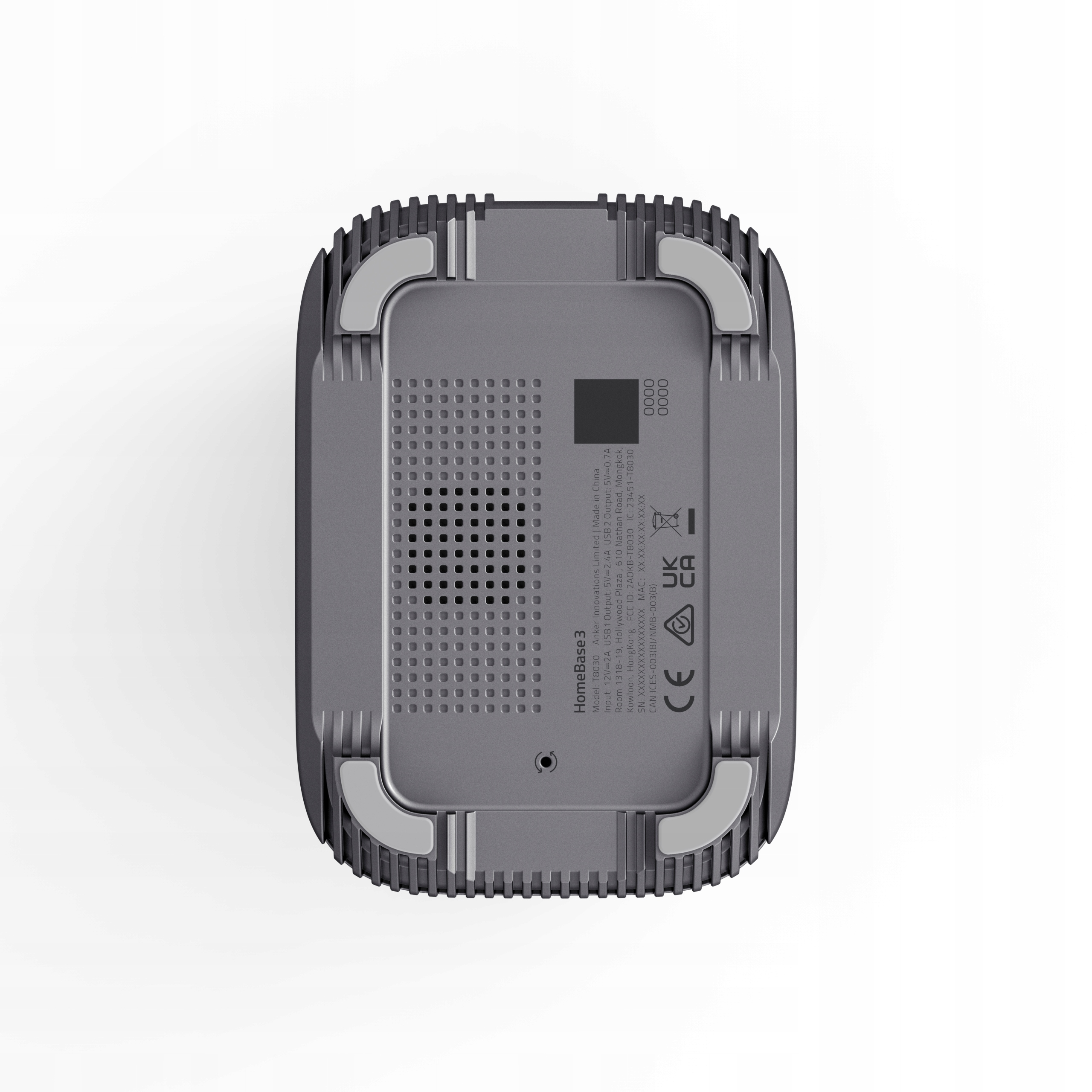 Spód szarego urządzenia, z siatką otworów i etykietami. Urządzenie ma zaokrąglone rogi.