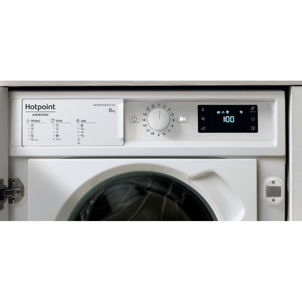 White Hotpoint washing machine control panel. It has buttons, a dial, and a digital display with the time.