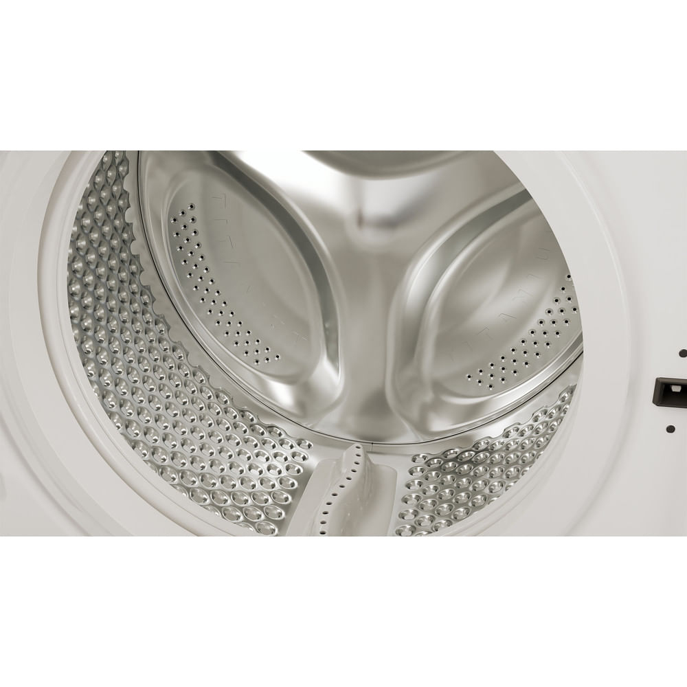 Close-up of a washing machine drum. The drum is silver and has numerous small holes.