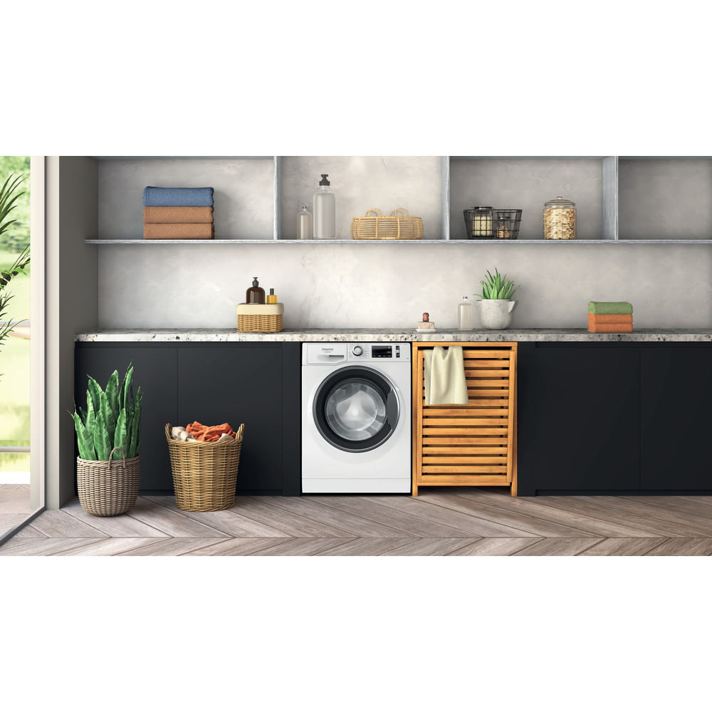 Una lavanderia con lavatrice, mensole e un mobile in legno.