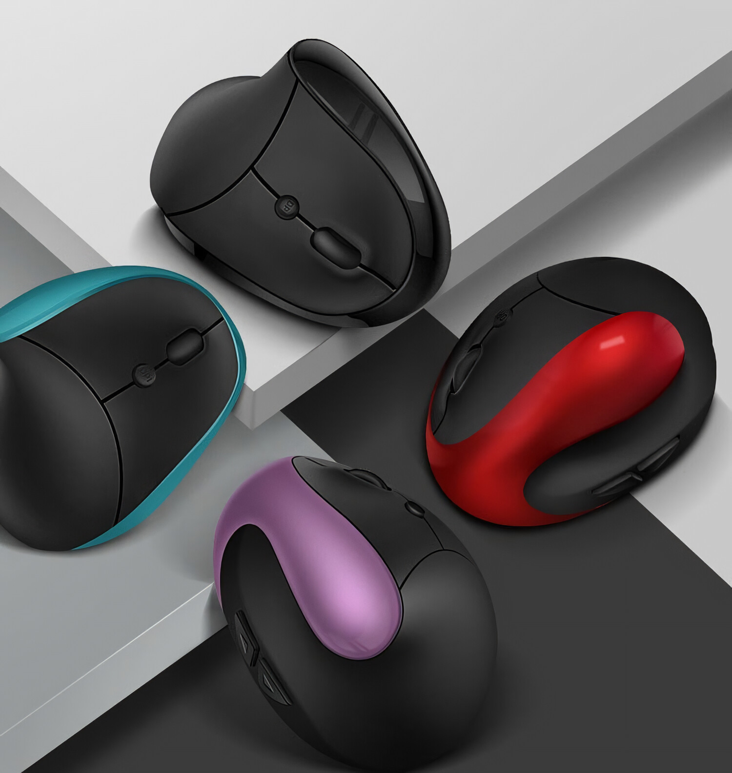 Vier ergonomische Mäuse in verschiedenen Farben: Schwarz, Blau, Rot und Lila, auf einer weißen und grauen Oberfläche angeordnet.