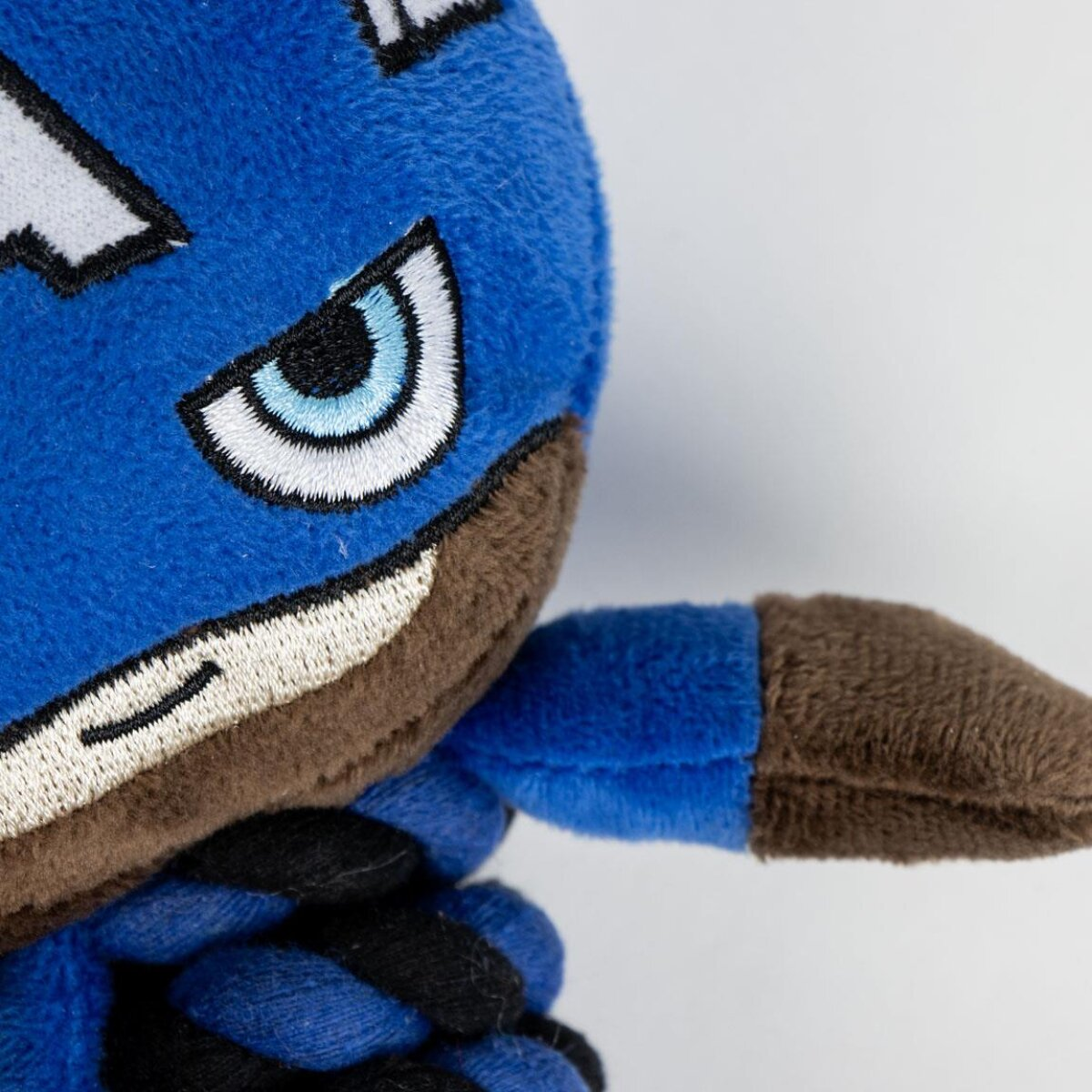 Nahaufnahme des Gesichts des Captain America Spielzeugs; blaue Maske, brauner Bart, weißes Auge, schwarzes Seil.