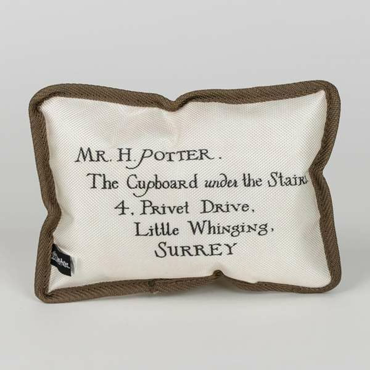 Ein weißes Kissen mit der Aufschrift: Mr. H. Potter, The Cupboard under the Stairs, 4 Privet Drive, Little Whinging, Surrey.