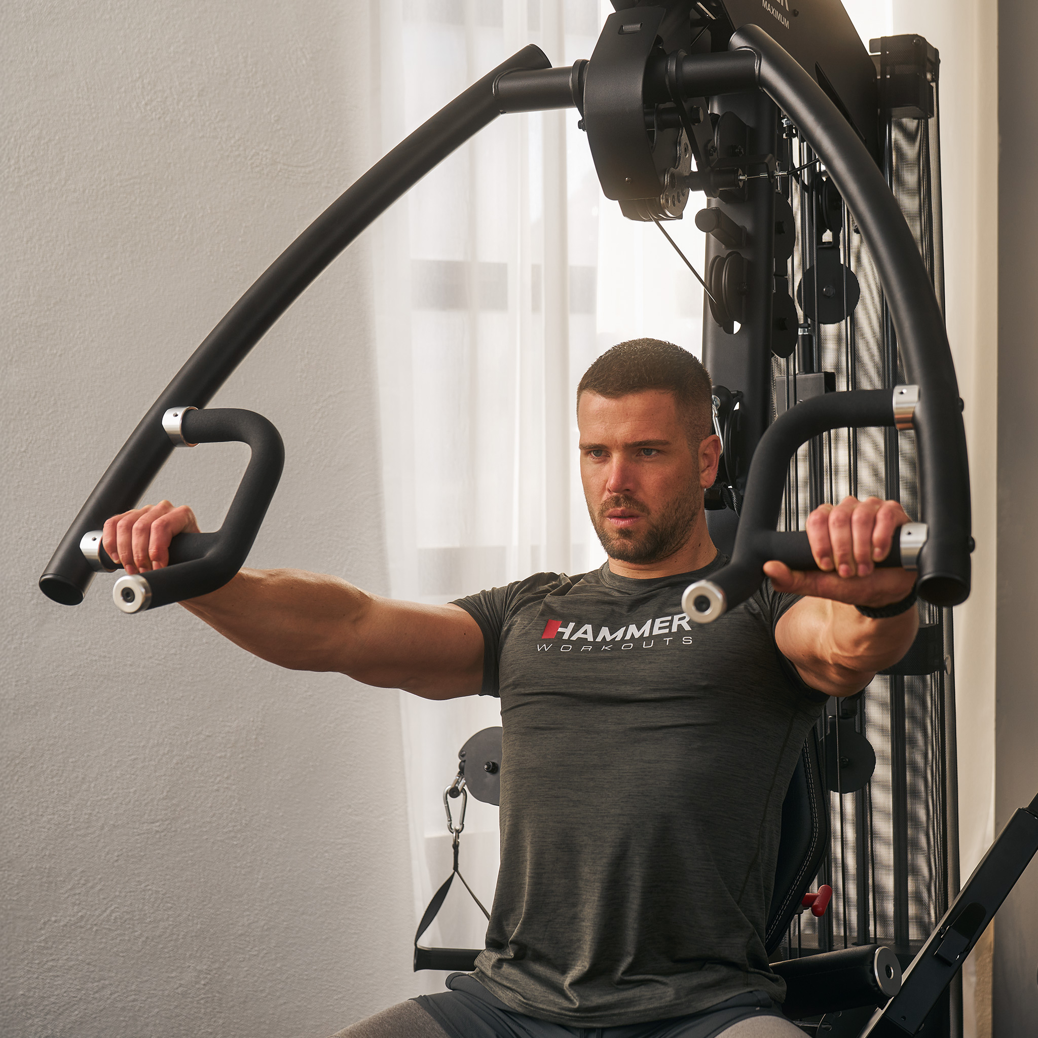 Ein Mann macht Brustübungen an einer schwarzen Hammer Heimtrainingsmaschine.