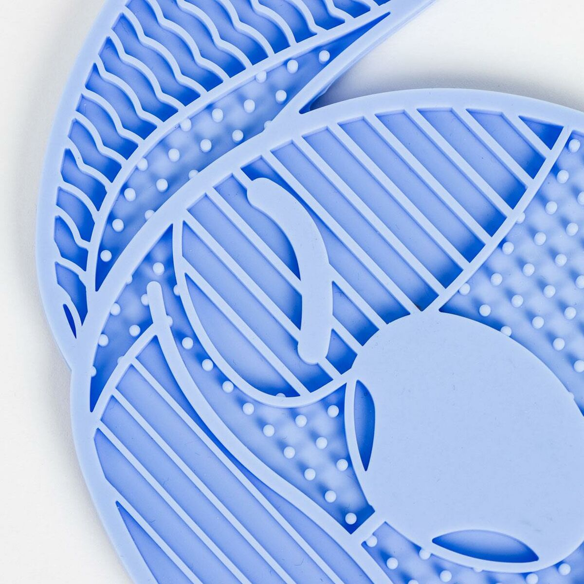 Nahaufnahme von blauen Matten, strukturiert mit Mustern. Eine Matte überlappt teilweise die andere.