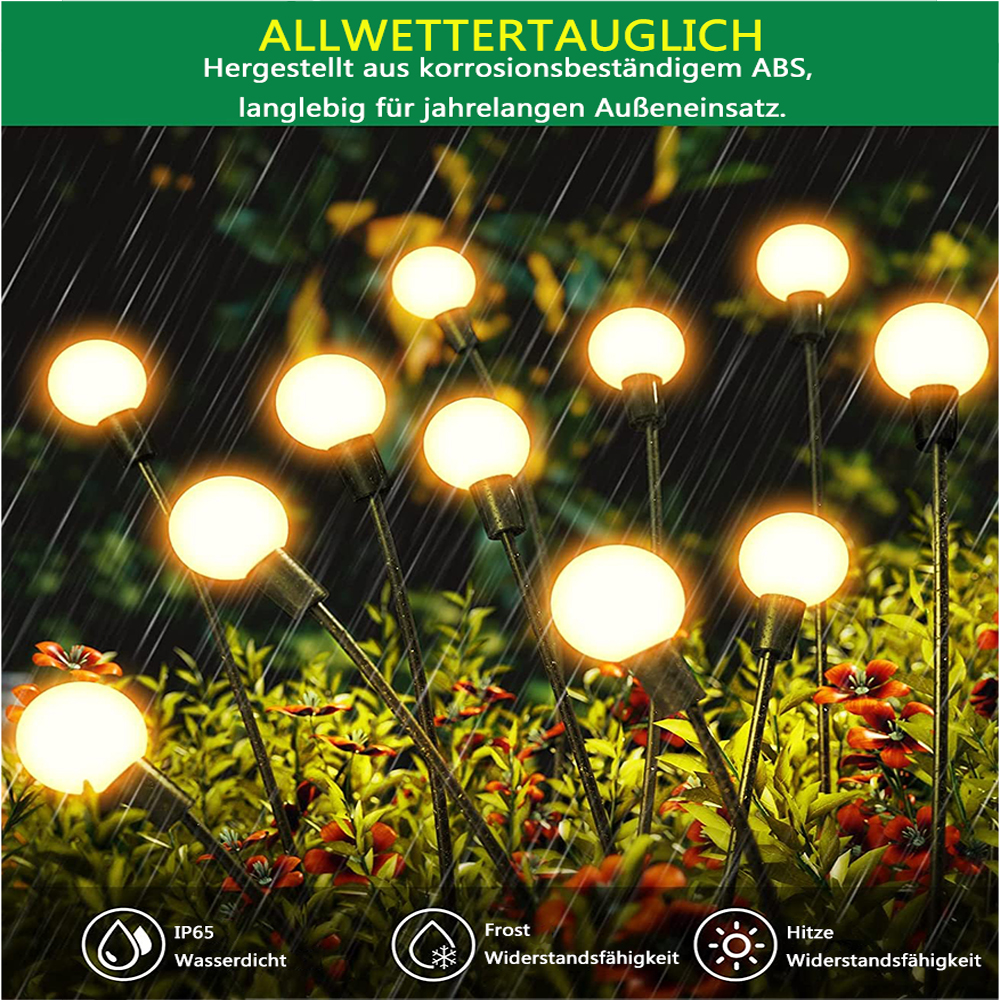 Gartenleuchten mit runden, beleuchteten Glühbirnen sind nachts zwischen Grün und Blumen zu sehen.