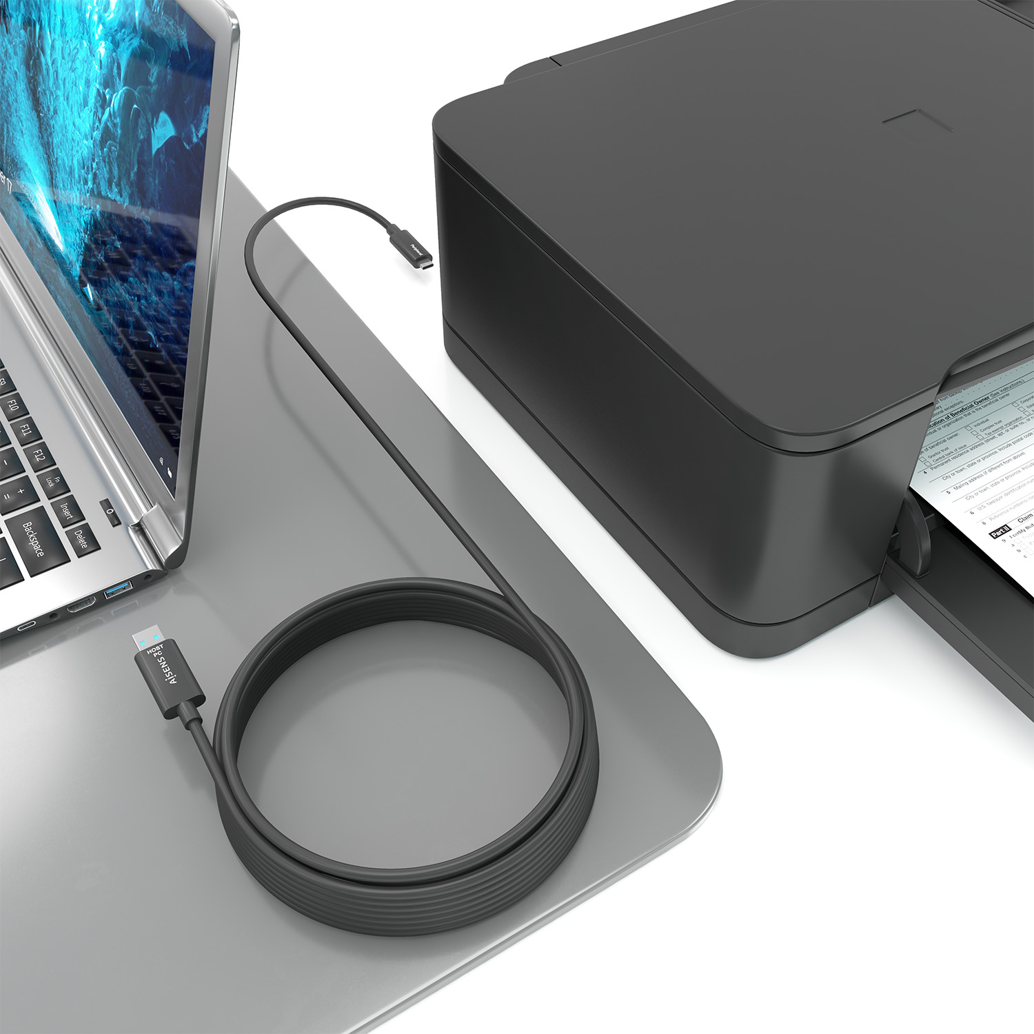 Portátil conectado a la impresora mediante cable en el escritorio, mostrando la configuración de la oficina en casa.