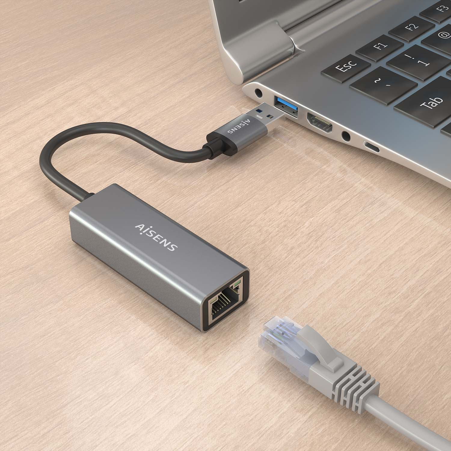Un adaptador gris con un puerto USB y un puerto Ethernet conectado a una computadora portátil con un cable.
