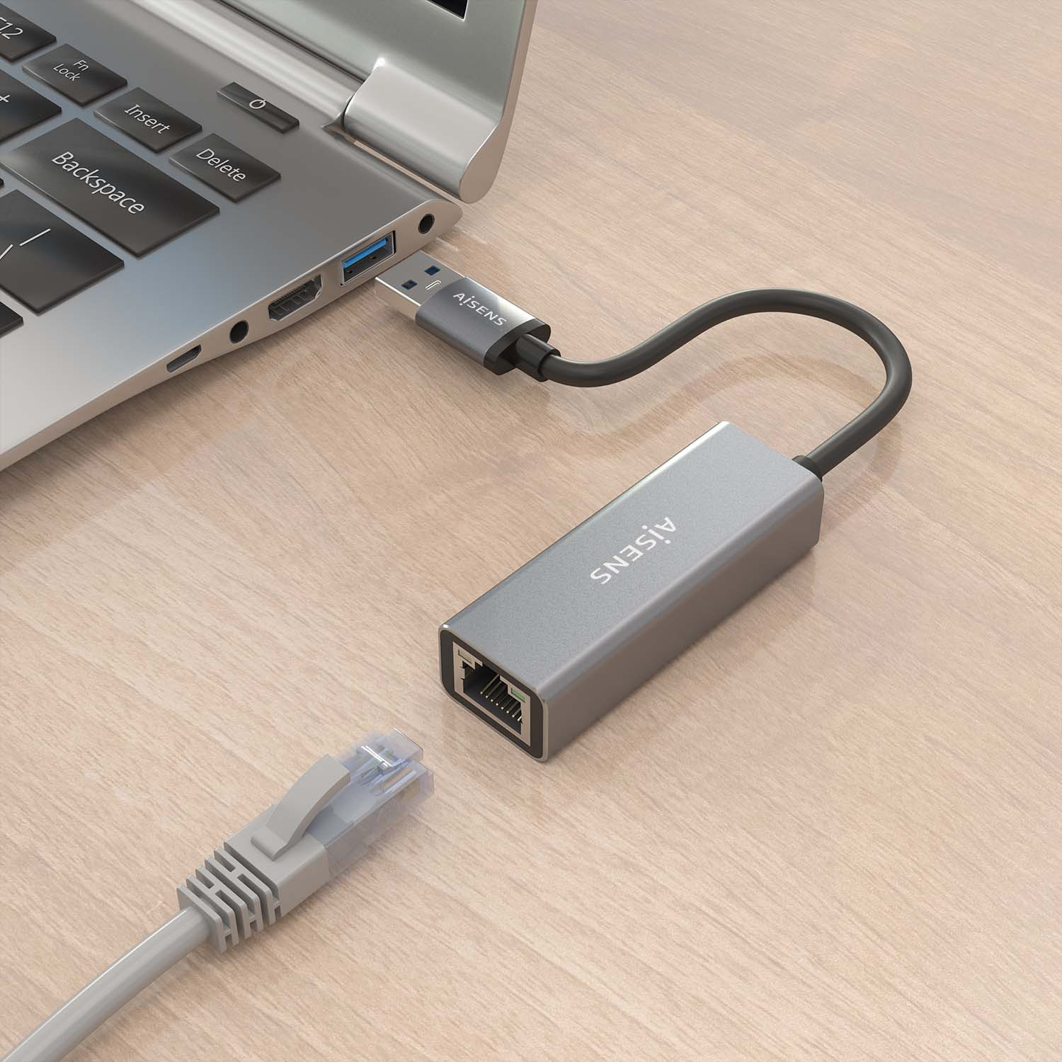 Un adaptador gris con un puerto USB y un puerto Ethernet conectado a una computadora portátil con un cable.