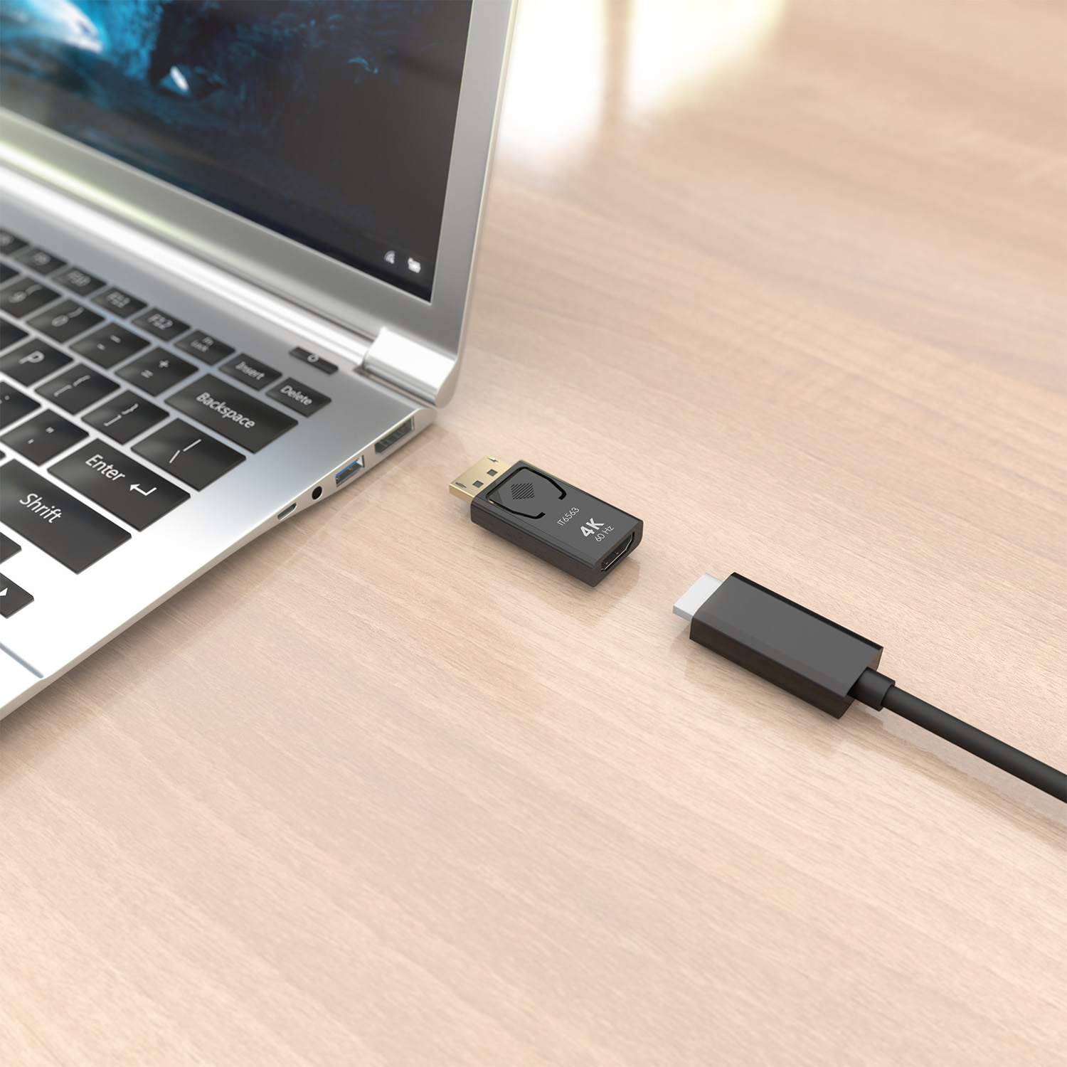 Un portátil se encuentra junto a un adaptador negro y un cable sobre una superficie de madera.