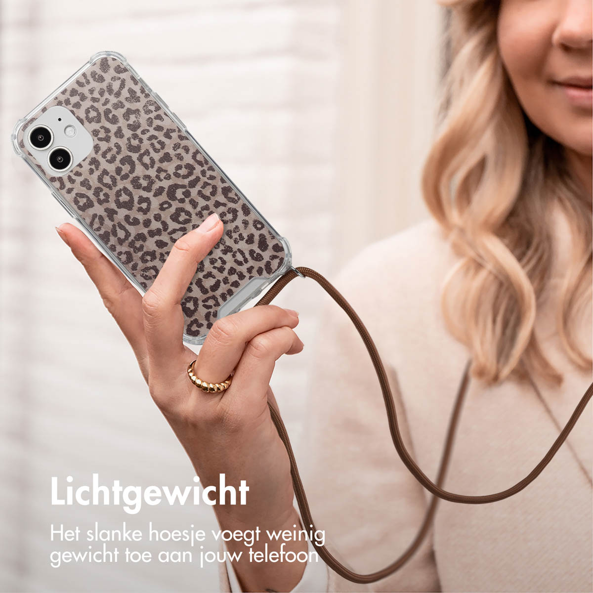 Une femme tient un téléphone avec un étui transparent avec un motif léopard.