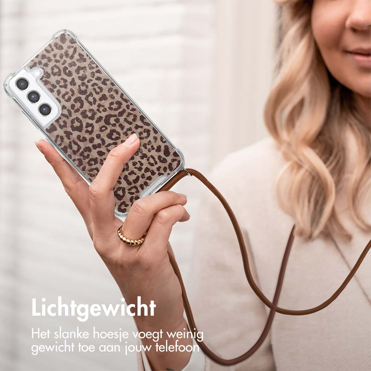 Een vrouw houdt een telefoon vast met een hoesje met luipaardprint. Tekst: "Lichtgewicht".