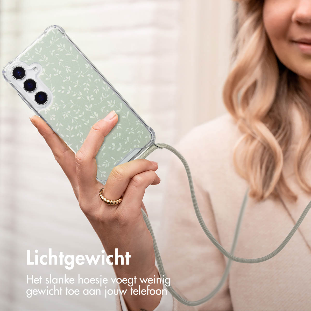 Vrouw met telefoon in een transparante hoes met een groen patroon, aan een koord. Tekst: 'Lichtgewicht'.