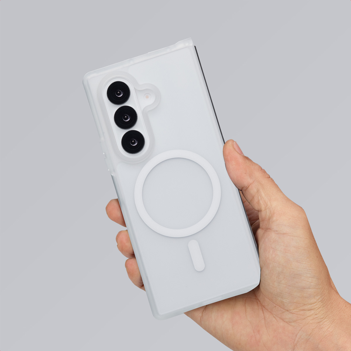 Een witte telefoonhoes met een witte cirkel in het midden wordt in een hand gehouden, getoond op een grijze achtergrond.