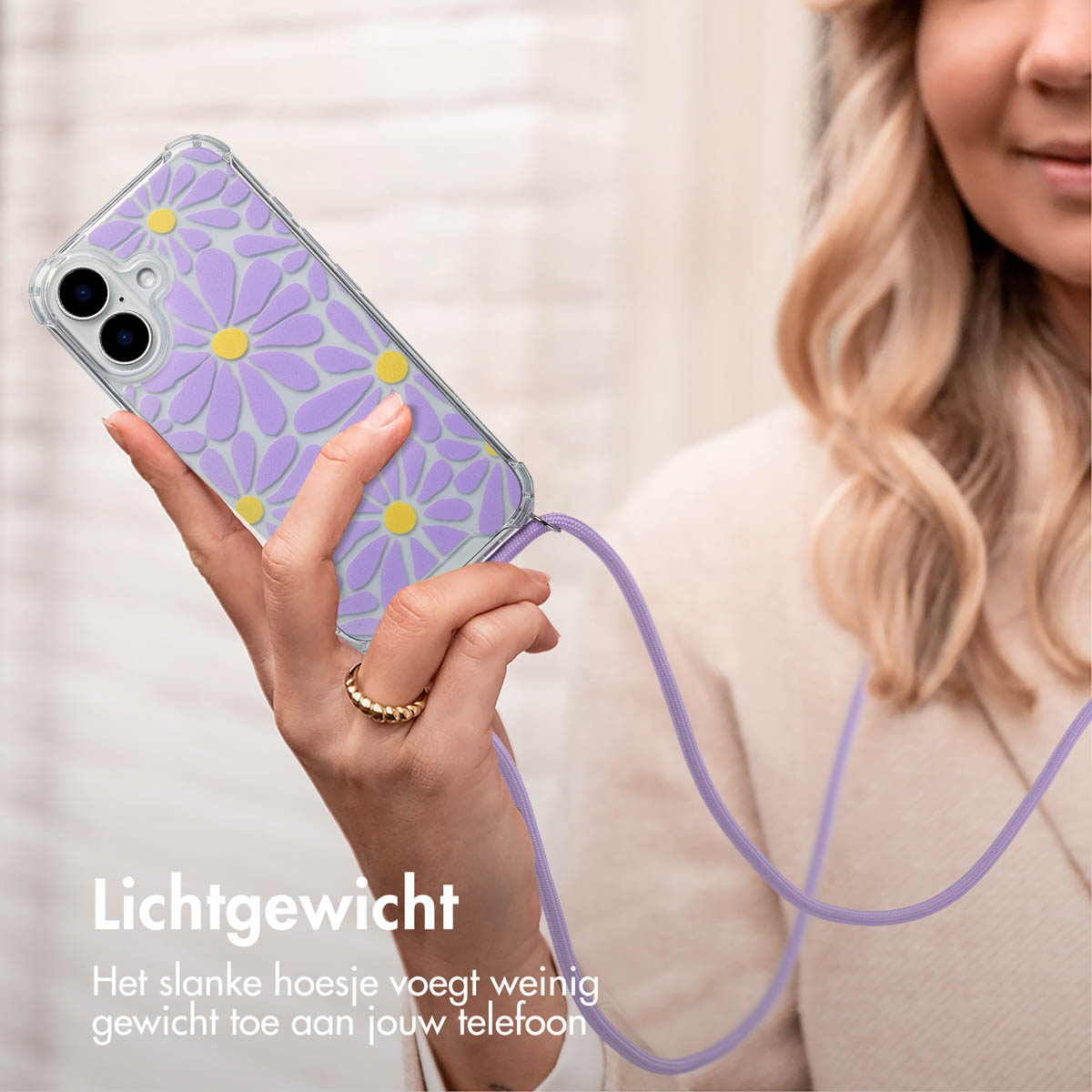 Vrouw met een telefoonhoesje met madeliefpatroon, met een paars koord.