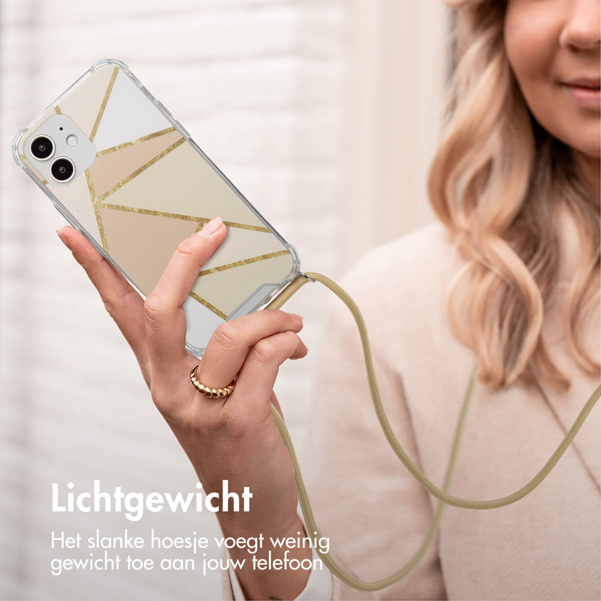 Vrouw die een telefoonhoesje met een geometrisch design vasthoudt. De telefoon is verbonden met een beige bandje.