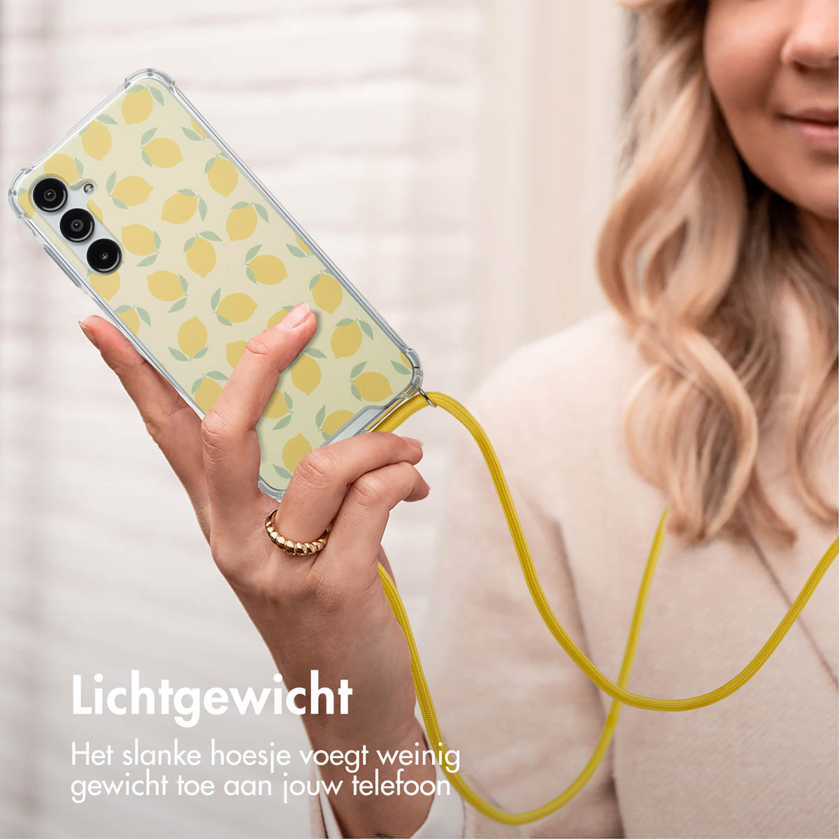 Een vrouw die een telefoon met een citroenpatroonhoesje vasthoudt. De telefoon hangt.