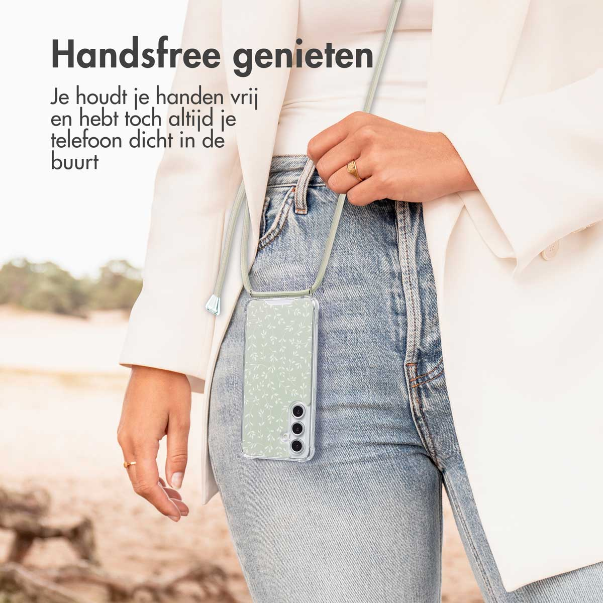 Femme avec étui et cordon de téléphone. L'étui a un motif de feuilles blanches et vertes, sur un jean.