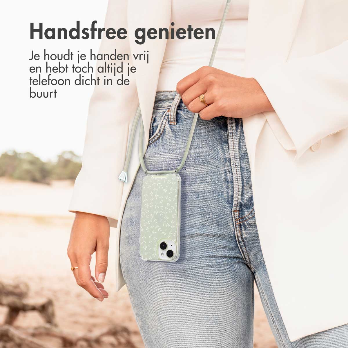 Femme tenant un téléphone avec une coque à motif de feuilles et une sangle.