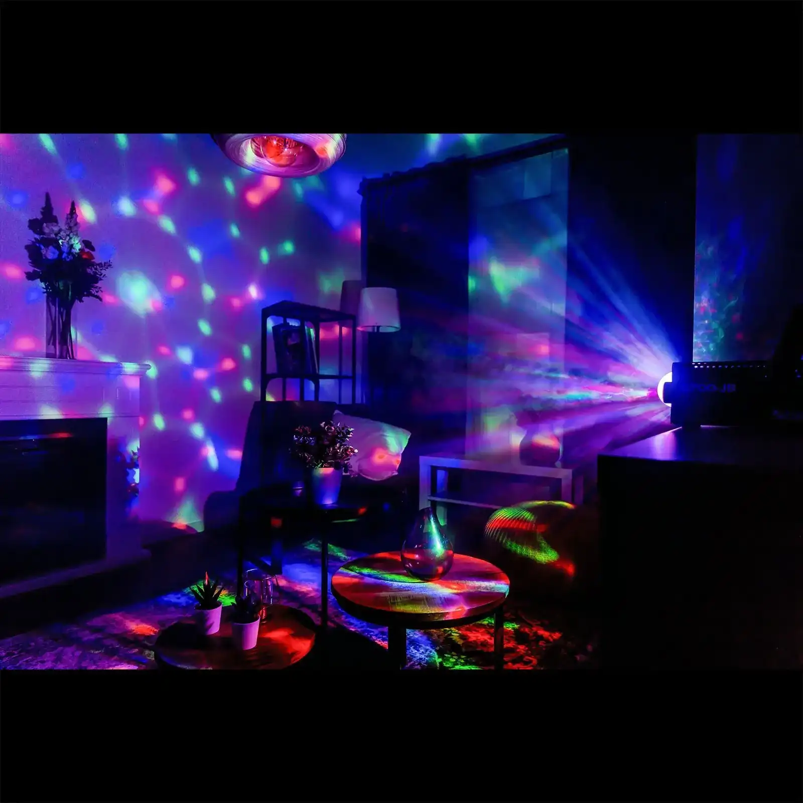 Habitación iluminada con luces de colores de una bola de discoteca y otras fuentes, creando un ambiente vibrante.