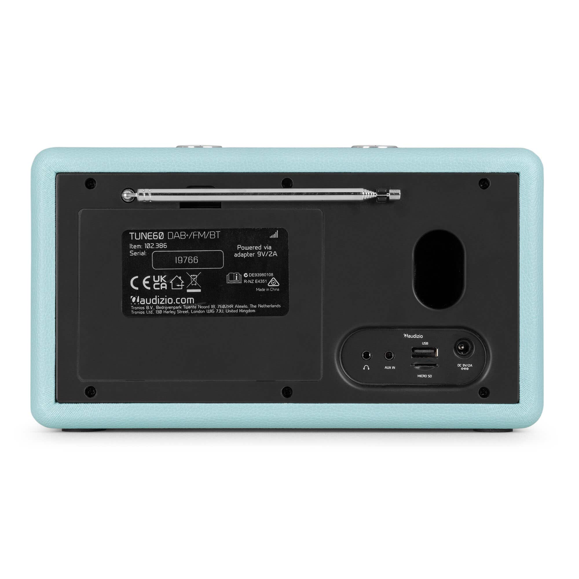 Parte trasera de una radio azul claro con varias etiquetas y antena. Puertos para aux in y USB.