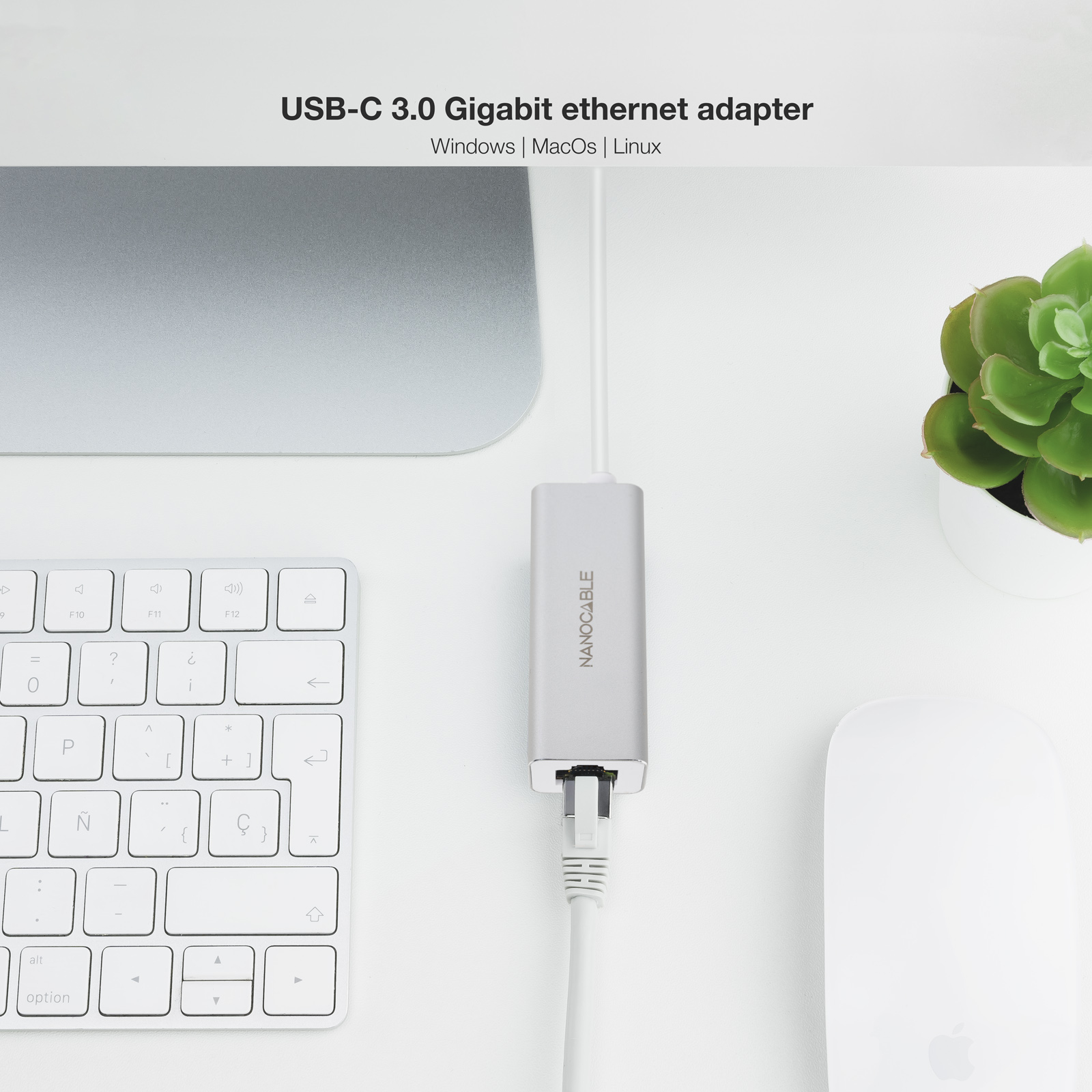 Adaptador USB-C a Ethernet en un escritorio blanco con teclado y ratón.