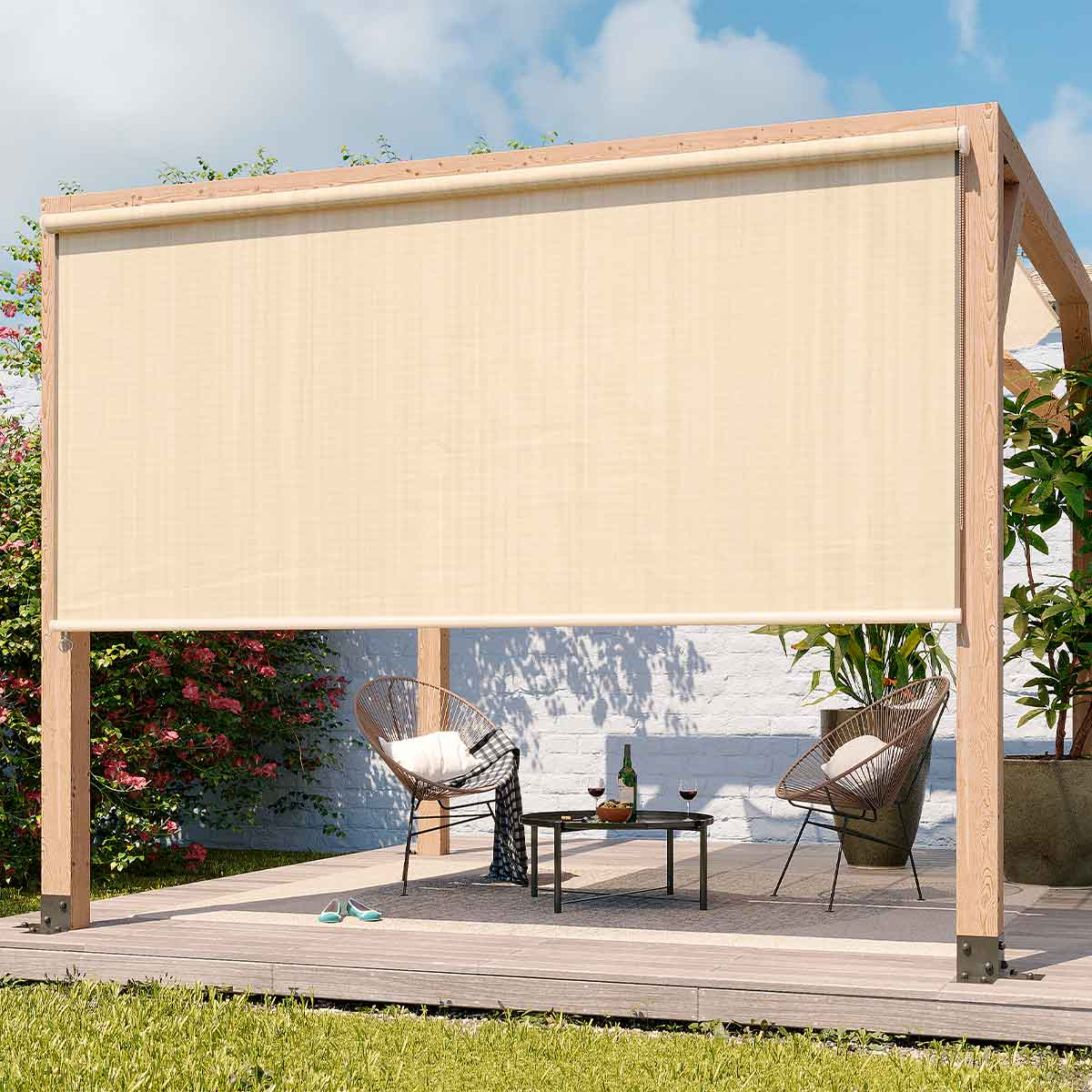 Een beige buitenzonnescherm is uitgerold, met stoelen, tafel en planten op een houten terras.