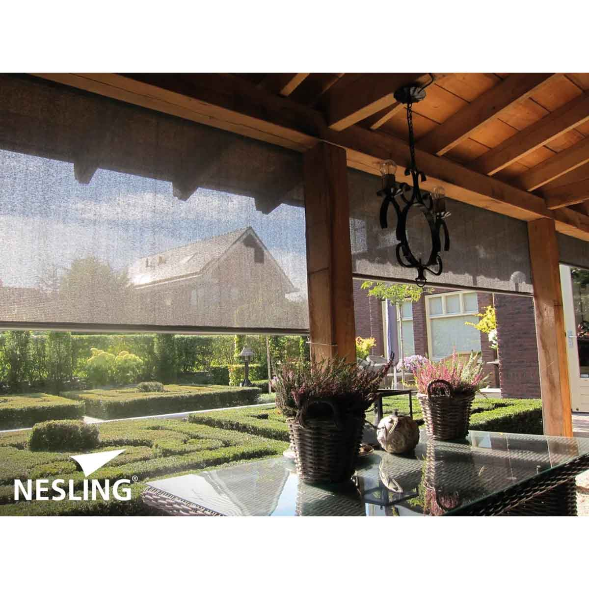 Buitenpatio met glazen tafel, planten en zicht op huis.