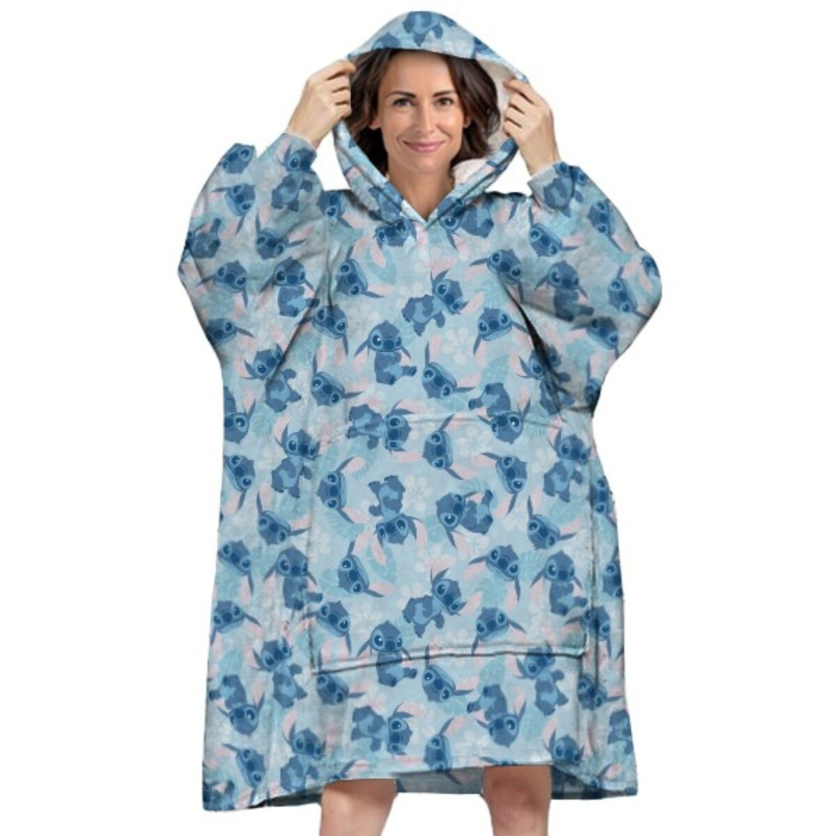 Eine Frau, die eine blaue Stitch-Kapuzen-Decke mit Stitch-Muster trägt, lächelt.