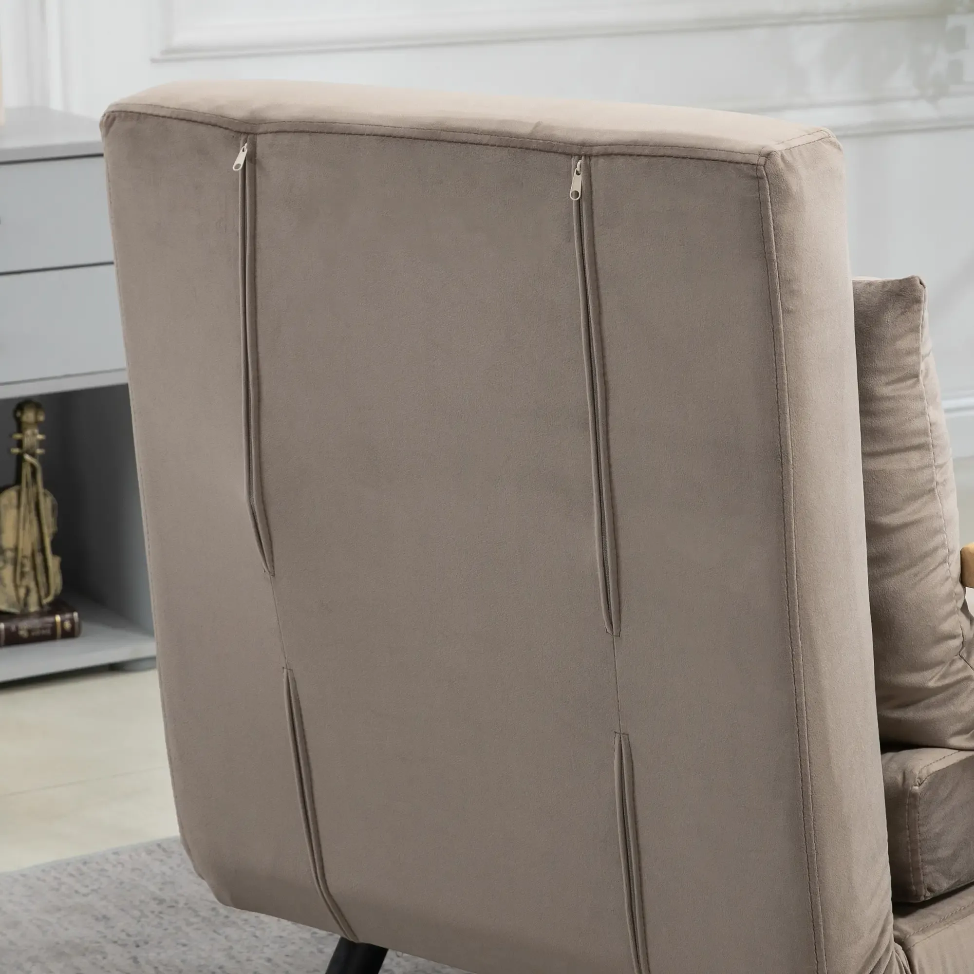 Rückseite eines beigen Schlafsofas mit Reißverschlüssen an der Rückenlehne.