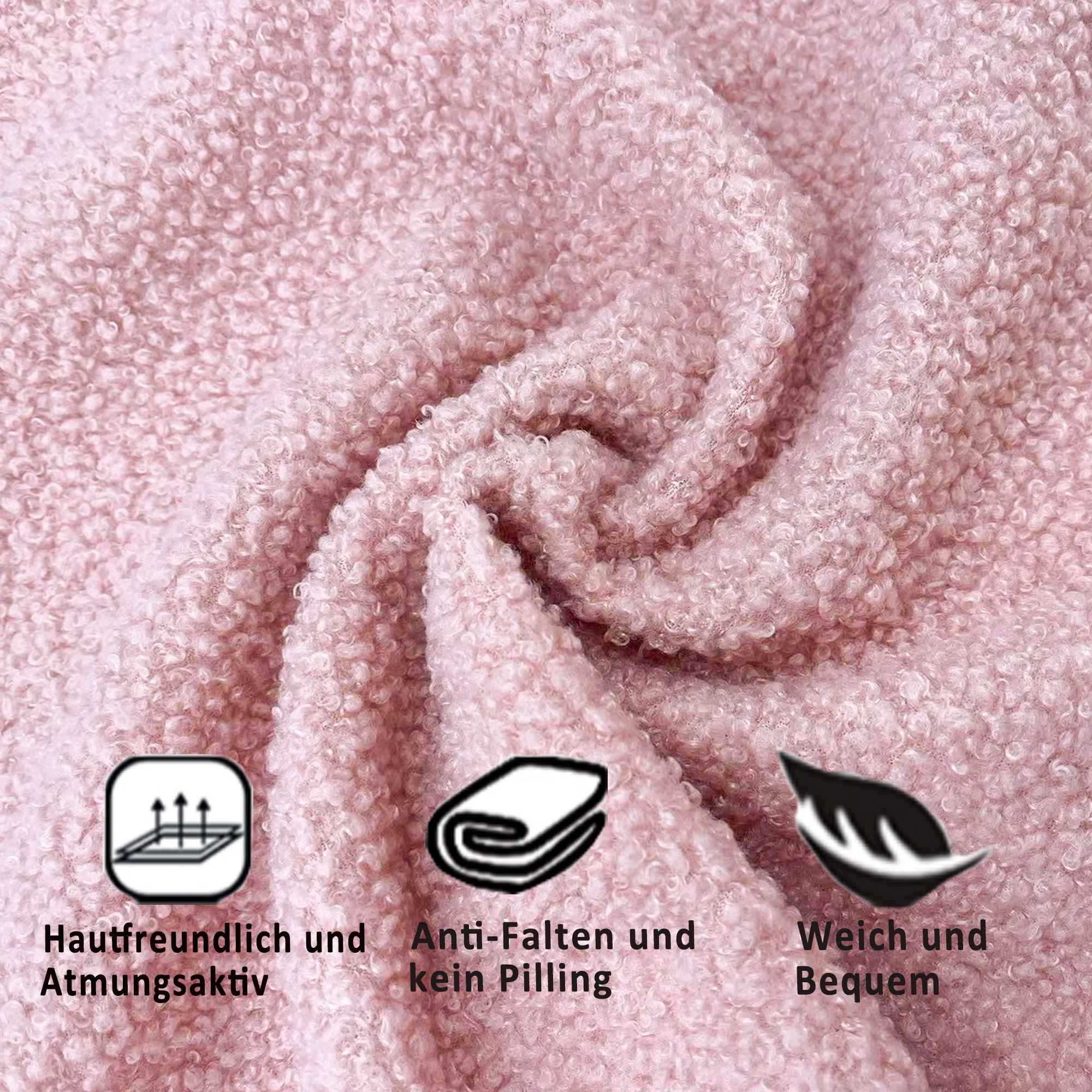 Nahaufnahme eines rosa, strukturierten Handtuchs mit drei Symbolen, die Atmungsaktivität und Weichheit anzeigen.
