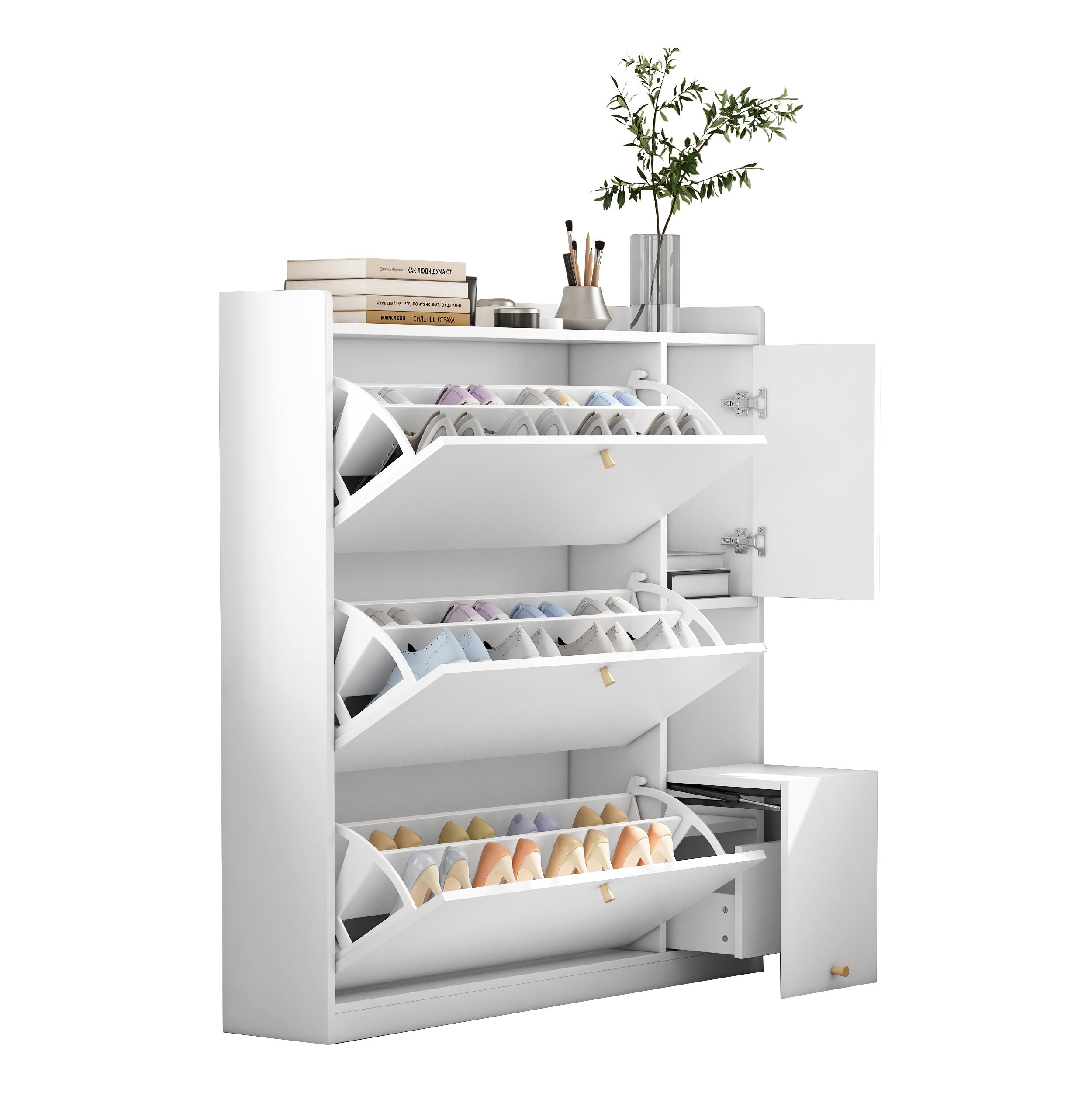 Weißer Schuhschrank mit geöffneten Fächern. Schuhe sichtbar. Bücher und Dekoration oben.