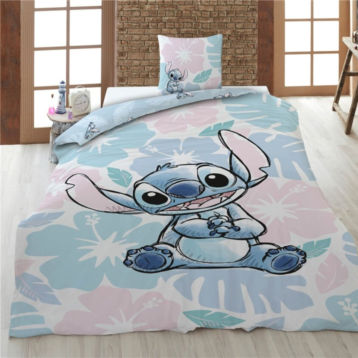 Een bed met een Stitch-thema sprei en kussen.