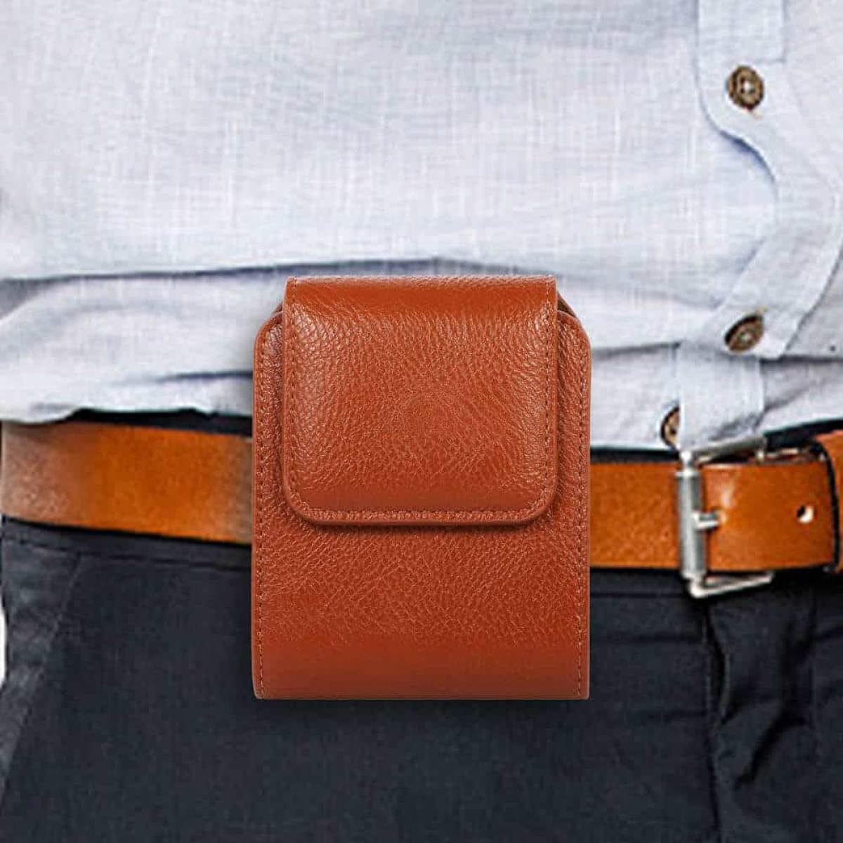 Eine braune Leder-Handyhülle an der Taille einer Person, befestigt an einem Gürtel.