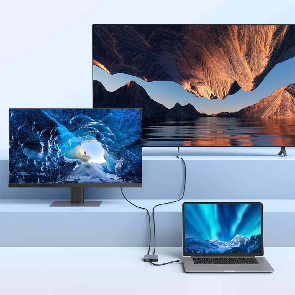 Ein Laptop, der mit einem Monitor und einem Fernseher verbunden ist. Sie zeigen unterschiedliche Inhalte, mit einem Hub.