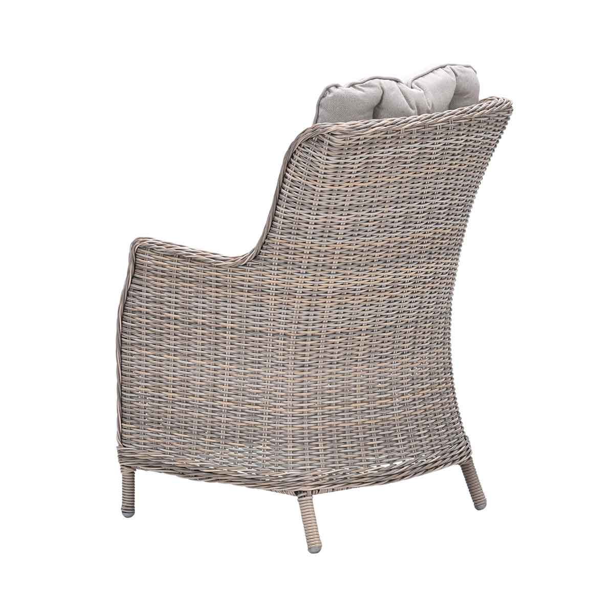 A wicker chair with a high back and a gray cushion. Back view, isolated on white.