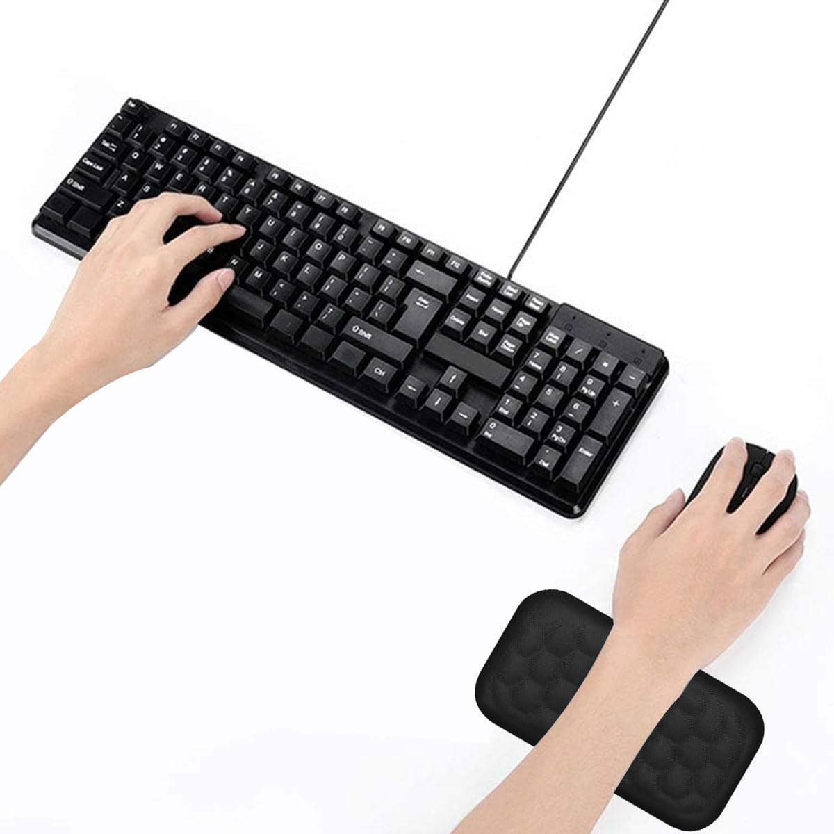 Hände, die eine Tastatur und Maus benutzen, mit einer schwarzen ergonomischen Handgelenkstütze auf weißer Oberfläche.