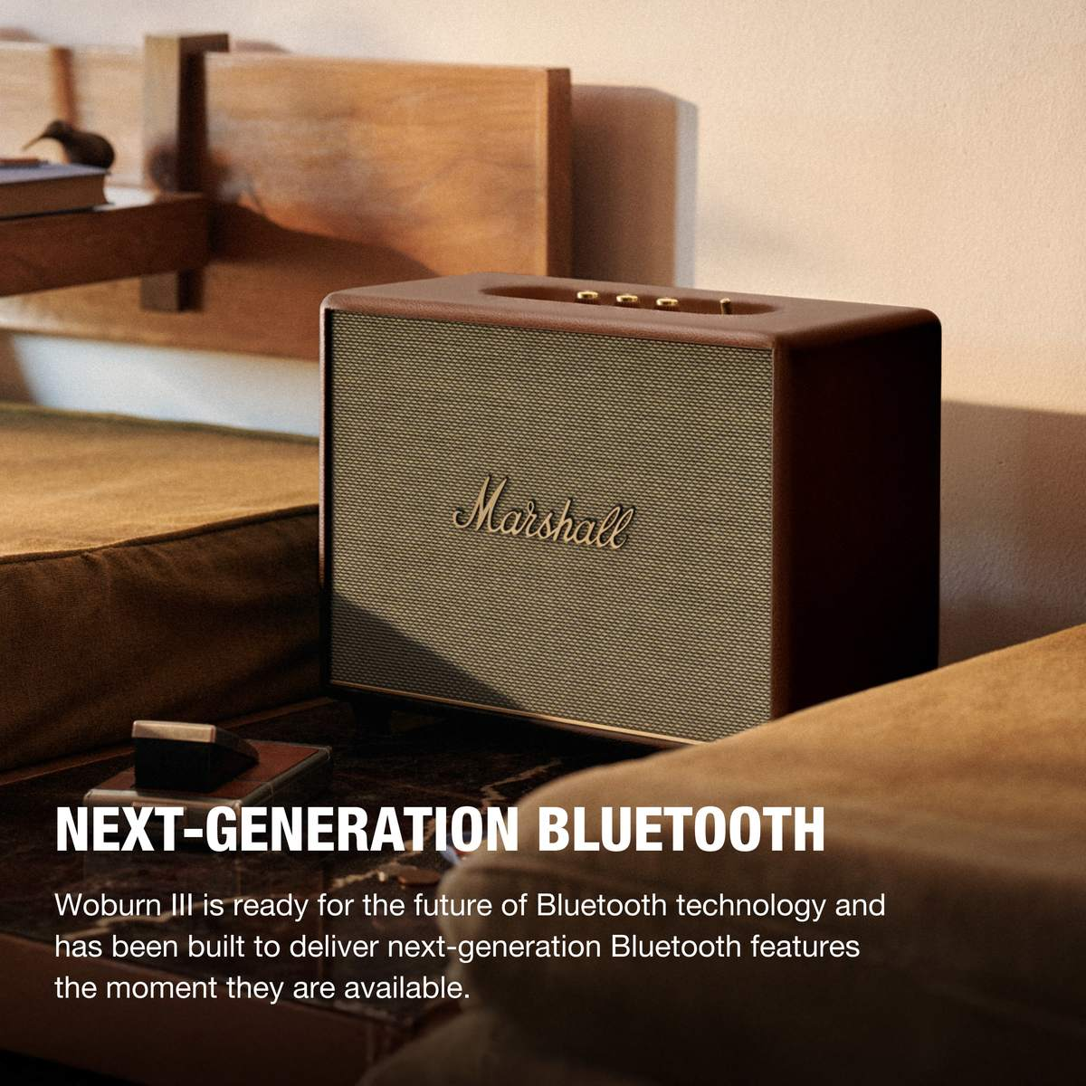 Ein Marshall-Lautsprecher auf einer Holzoberfläche. Text: NEXT-GENERATION BLUETOOTH.