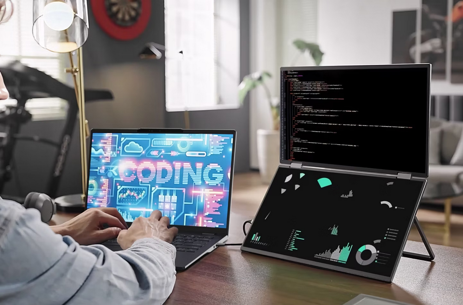 Person codiert auf Laptop, mit zweitem Bildschirm mit Code. Schreibtisch, Lampe und Kopfhörer sind sichtbar.