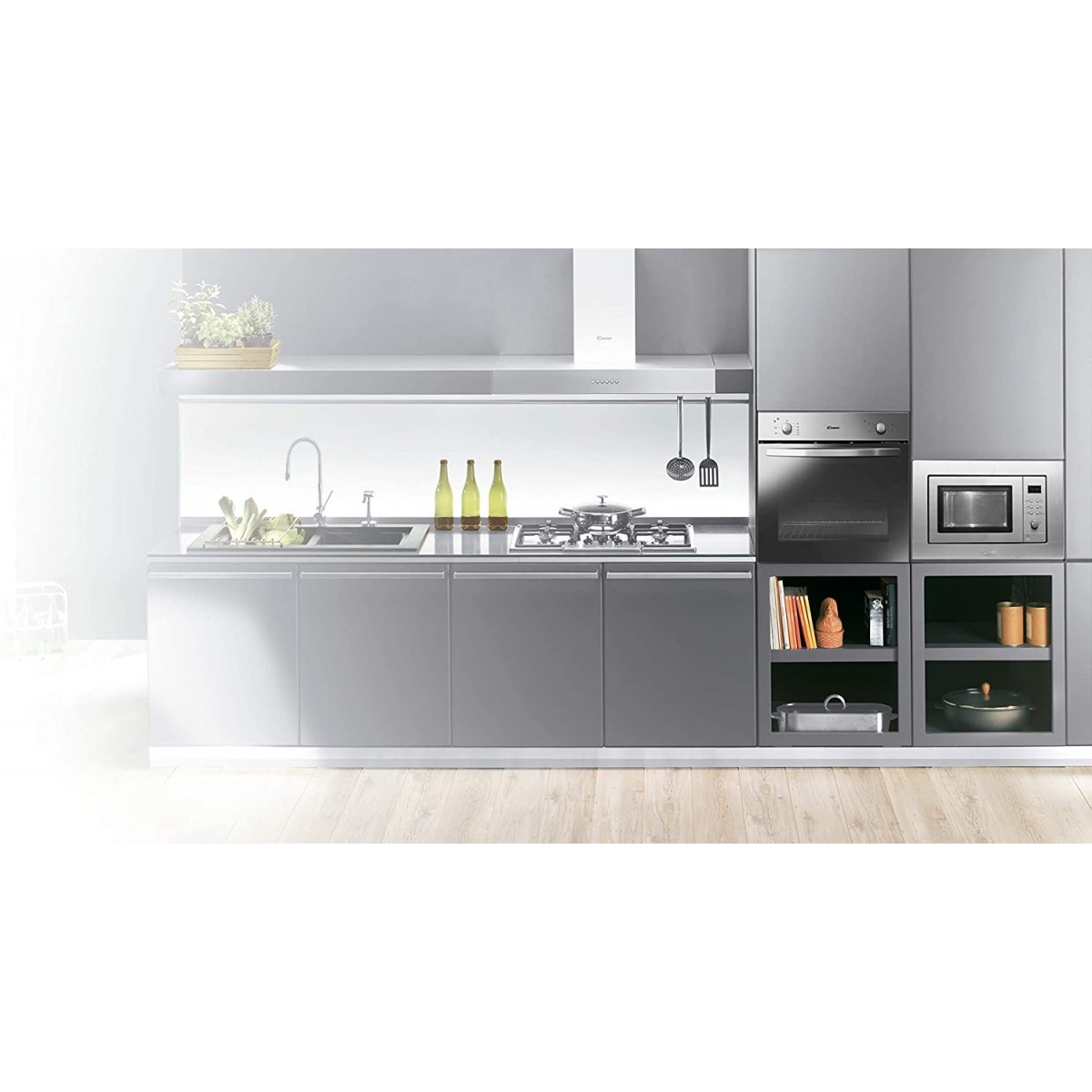 Nowoczesna kuchnia. Ma szare szafki, kuchenkę, piekarnik, kuchenkę mikrofalową i drewniane podłogi.