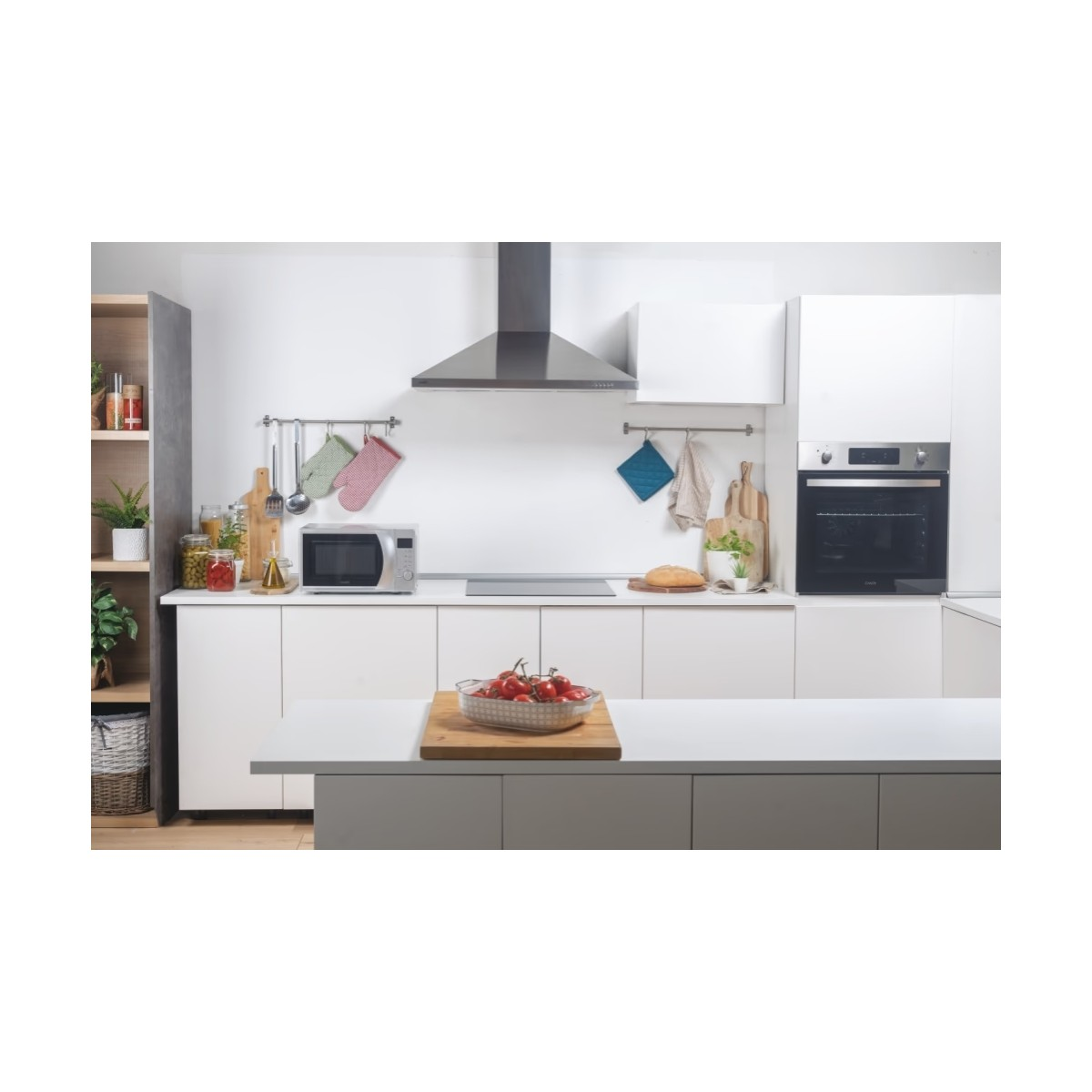 Nowoczesna kuchnia z białymi szafkami, okapem ze stali nierdzewnej i kuchenką mikrofalową.