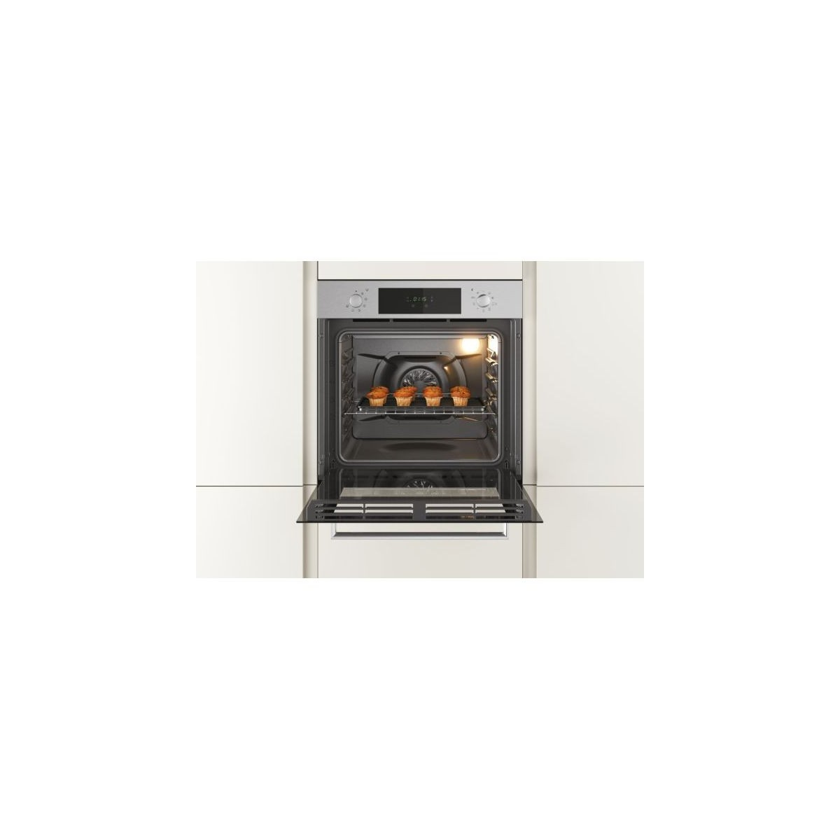 Un forno aperto con sei muffin all'interno, in un interno cucina bianco.