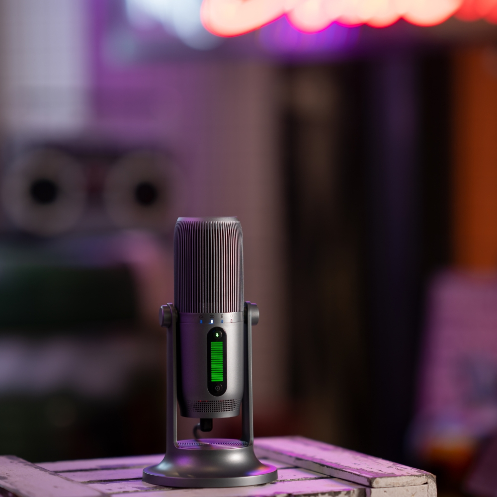 Un microfono argentato è su una scatola di legno bianca. Lo sfondo è sfocato con luci al neon.